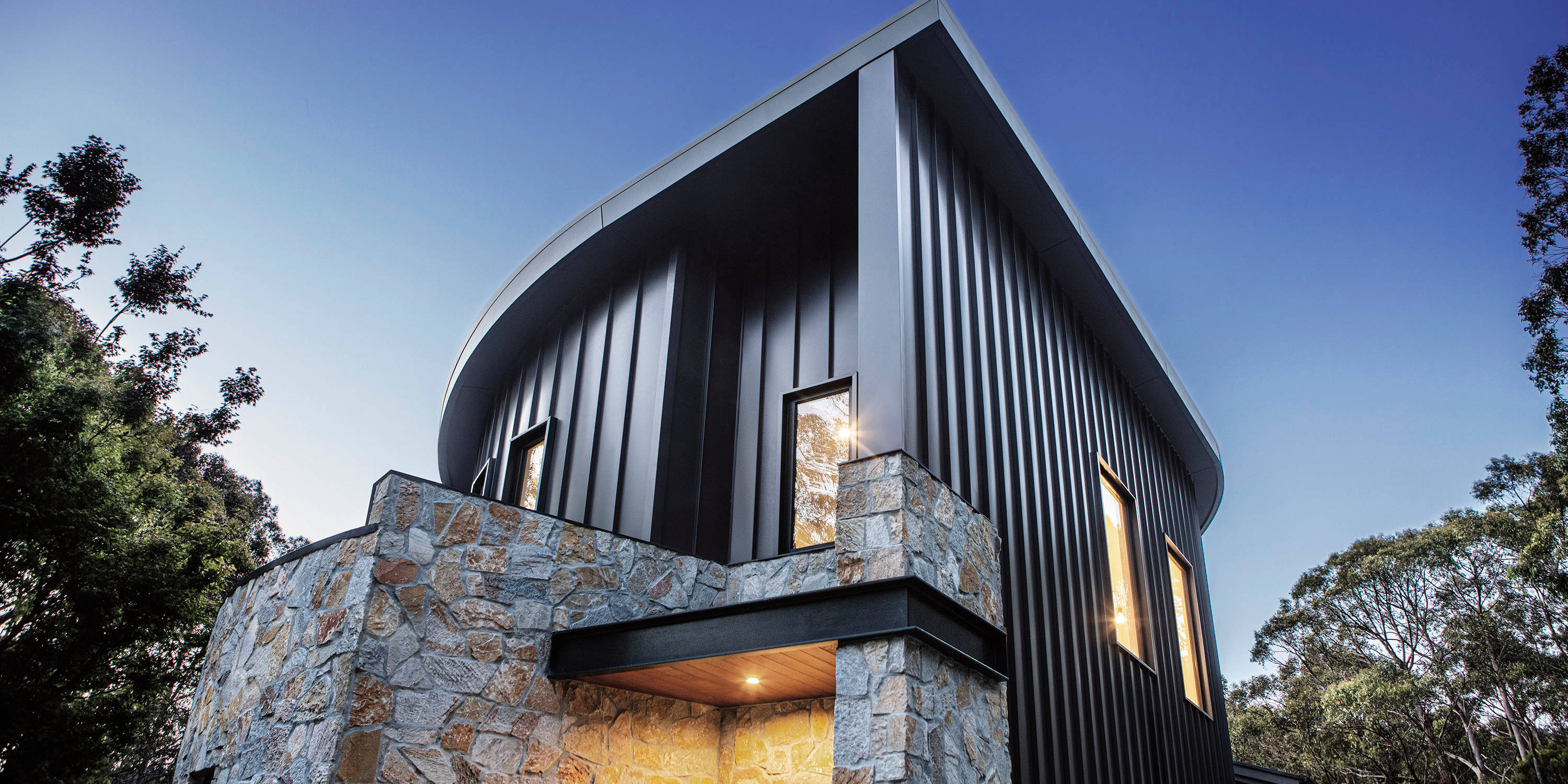 Modern architectural home with curved standing seam Hiland Tray external walling